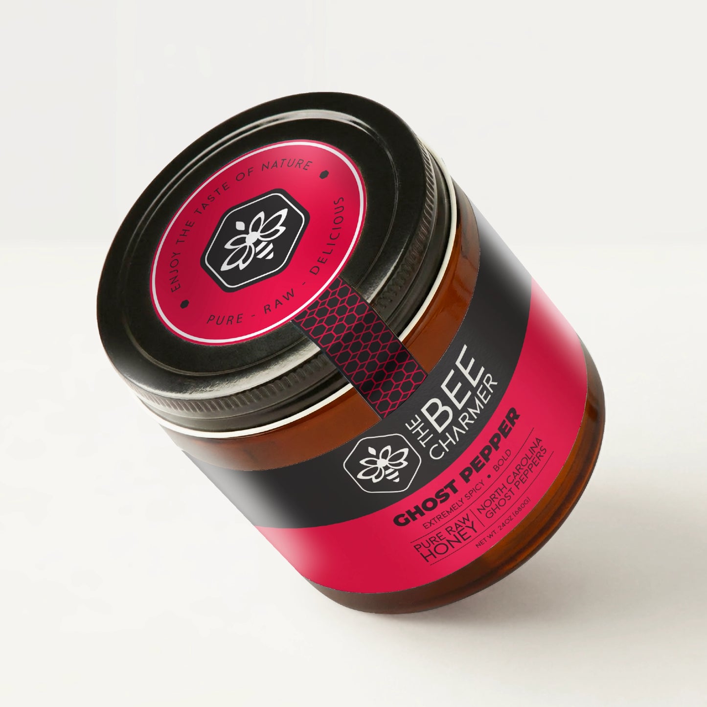 Hot pepper-infused Ghost Pepper Honey in a signature Bee Charmer branded 24oz wide-mouth glass jar showing the top of the jar label.