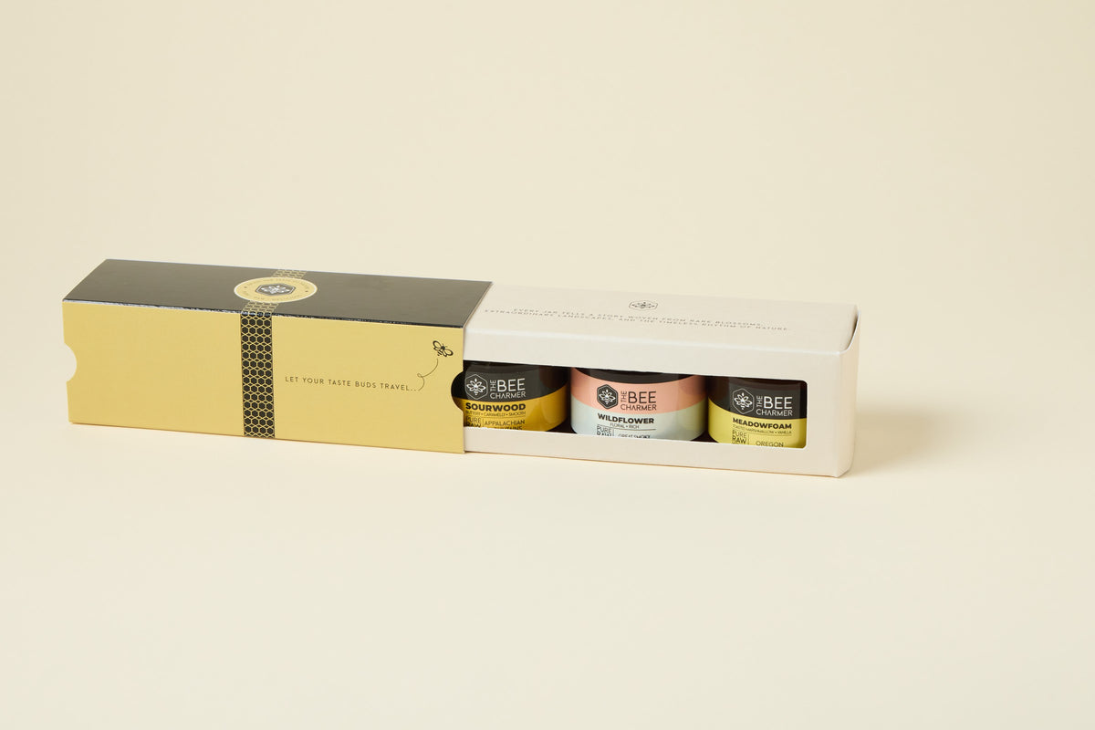 Honey 3-Pack gift box with the gold sleeve slid open to show Sourwood, Wildflower and Meadowfoam raw honey jars