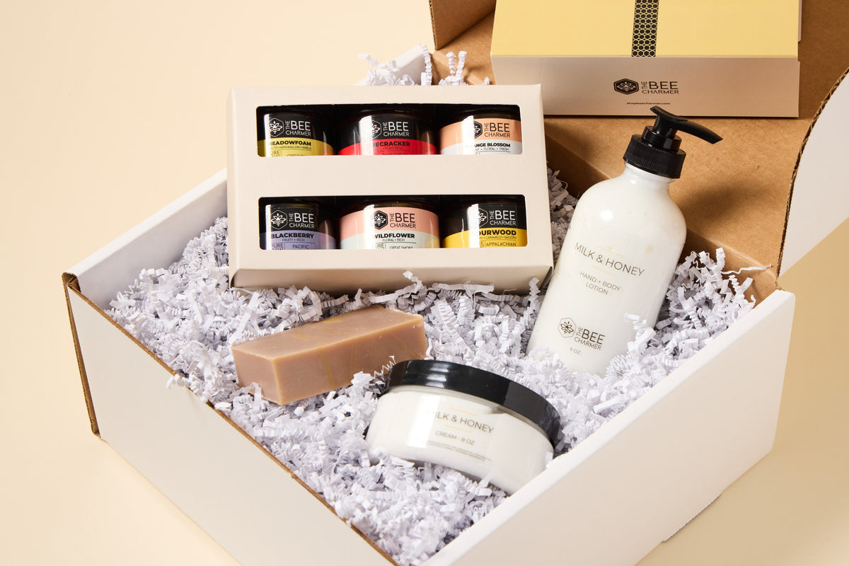 The Bee Charmer Collection Gift Set: six jars of raw honey with Milk and Honey bar soap, lotion and cream in a shipping box